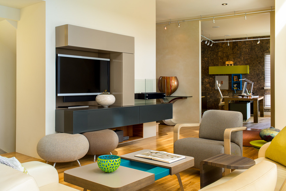 Inspiration pour une salle de séjour design ouverte avec un mur beige, un sol en bois brun et un téléviseur encastré.