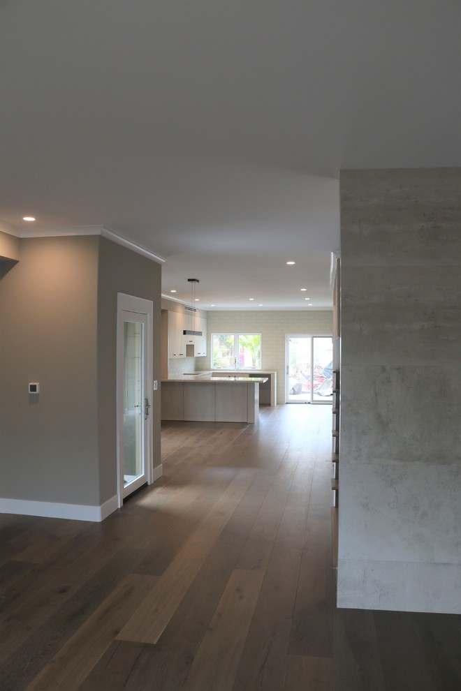 Idee per un grande soggiorno design aperto con pareti beige, pavimento in legno massello medio, nessun camino e TV nascosta