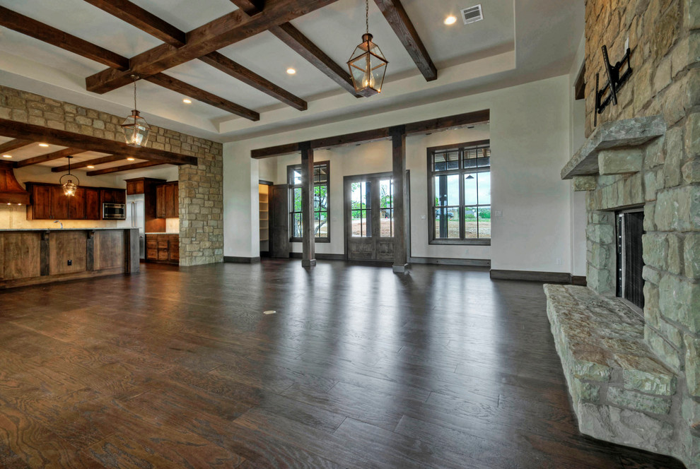 Inspiration for a country open plan games room in Austin with dark hardwood flooring, a standard fireplace and a stone fireplace surround.