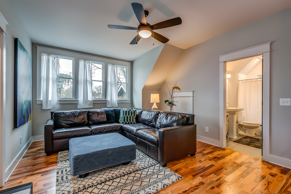 Modelo de sala de estar clásica renovada con paredes grises y suelo de madera en tonos medios