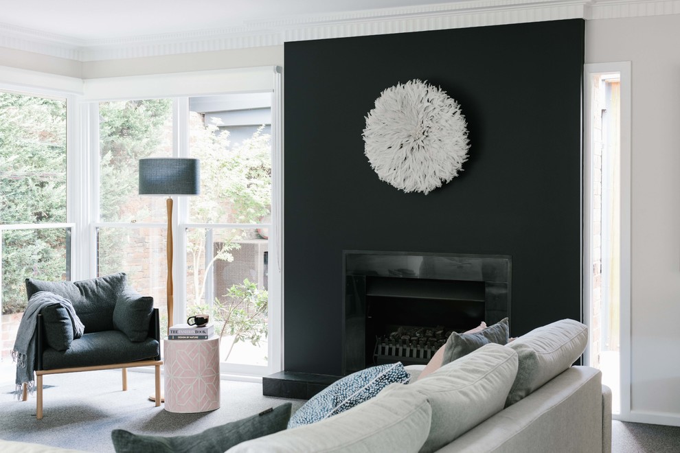 メルボルンにある中くらいなトランジショナルスタイルのおしゃれなLDK (黒い壁、カーペット敷き、標準型暖炉、タイルの暖炉まわり、グレーの床、アクセントウォール) の写真