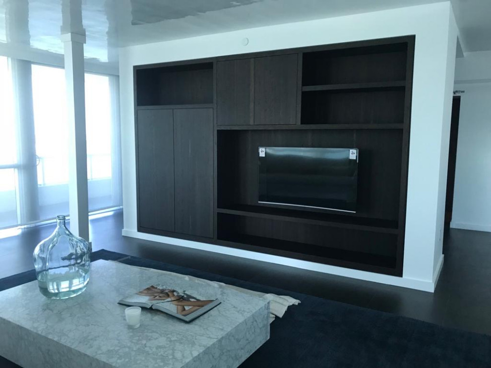 Esempio di un piccolo soggiorno minimalista aperto con pareti bianche, parquet scuro, parete attrezzata e pavimento nero