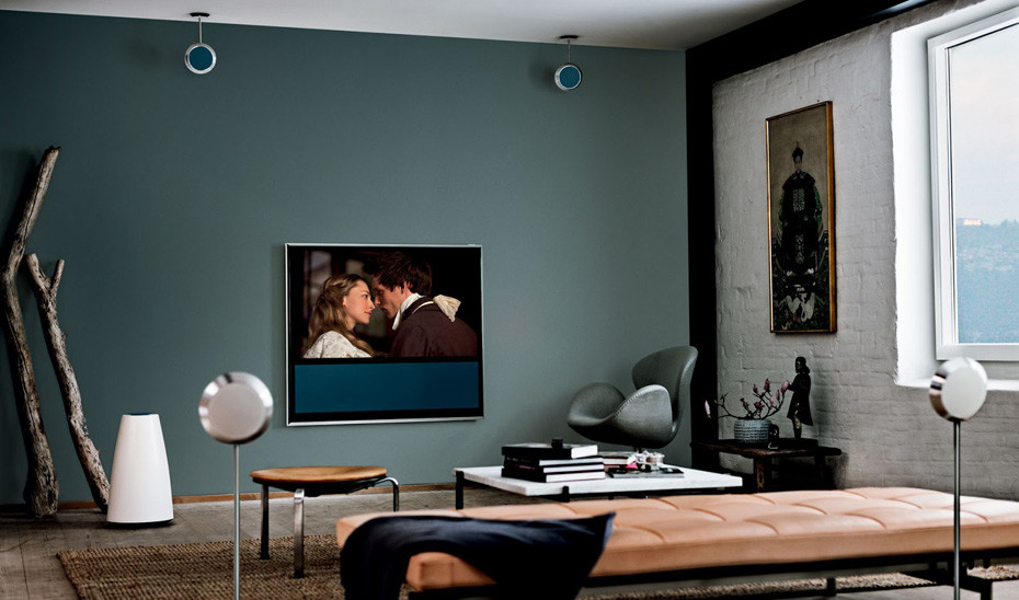 Modelo de sala de estar moderna pequeña con paredes azules, suelo de madera oscura y televisor colgado en la pared