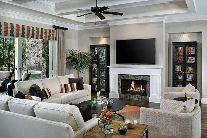 Inspiration for an expansive classic open plan games room in Tampa with beige walls, medium hardwood flooring, a standard fireplace, a wooden fireplace surround and a wall mounted tv.