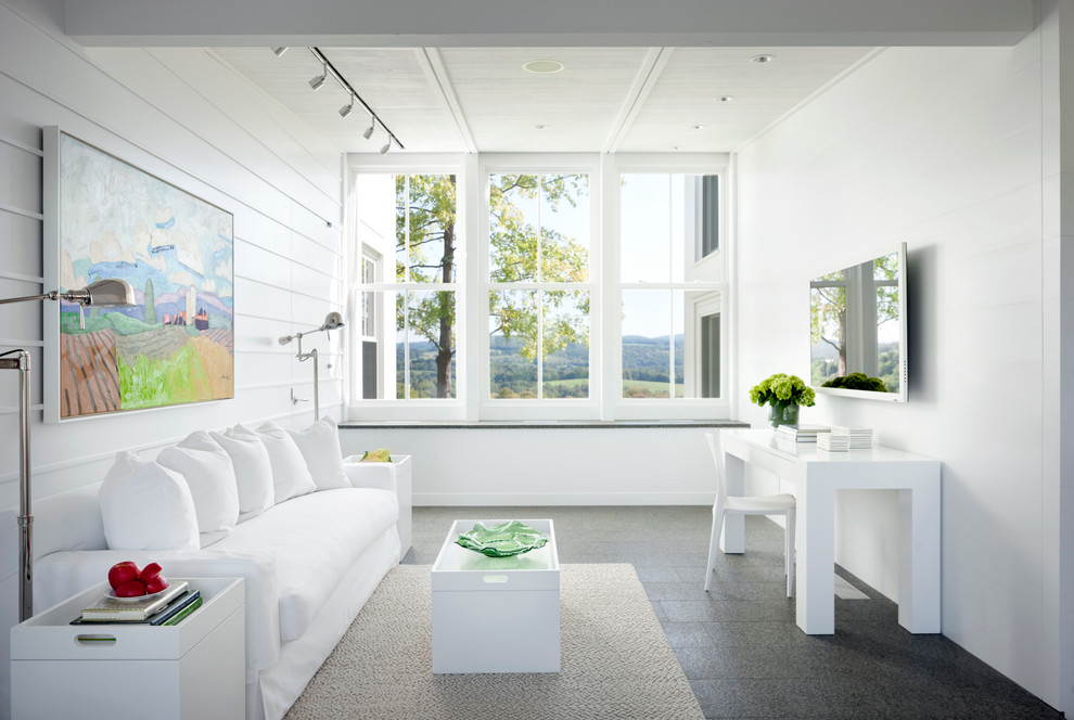 На фото: изолированная гостиная комната в стиле кантри с белыми стенами и телевизором на стене без камина
