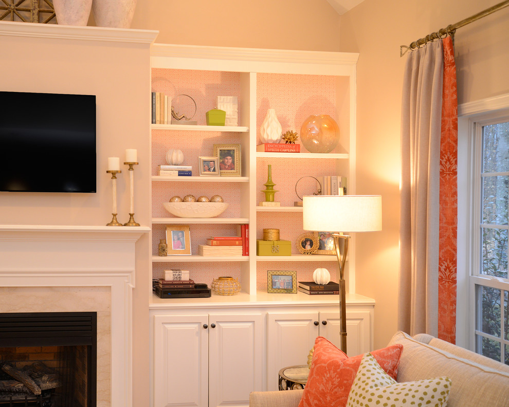 Cette photo montre une salle de séjour chic ouverte avec un mur beige, un sol en bois brun, une cheminée standard, un manteau de cheminée en bois et un téléviseur fixé au mur.