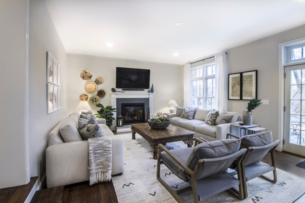 This is an example of a medium sized contemporary open plan games room in DC Metro with grey walls, dark hardwood flooring, a standard fireplace, a concrete fireplace surround, a wall mounted tv and brown floors.
