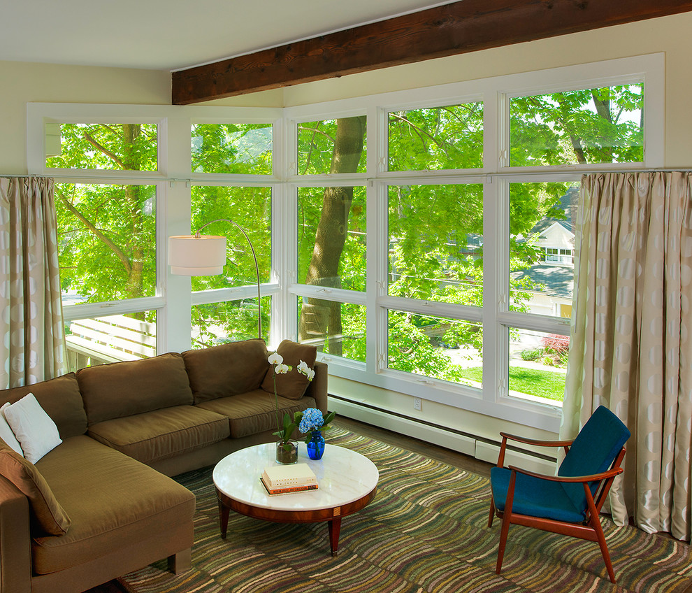 Пример оригинального дизайна: гостиная комната в современном стиле с желтыми стенами, коричневым диваном и ковром на полу