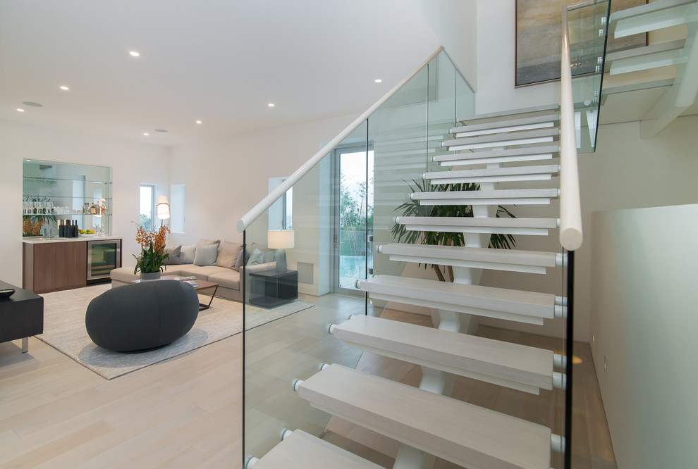 Mittelgroßes, Fernseherloses, Offenes Modernes Wohnzimmer ohne Kamin mit Hausbar, hellem Holzboden und beigem Boden in Los Angeles