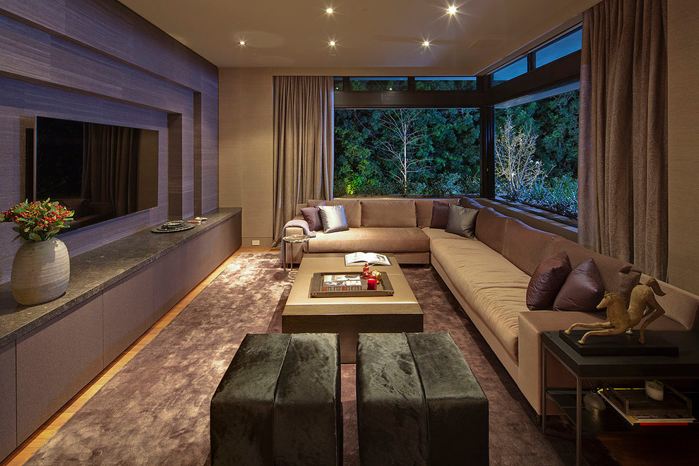 Ejemplo de sala de estar abierta minimalista grande con paredes púrpuras, suelo de madera en tonos medios y pared multimedia