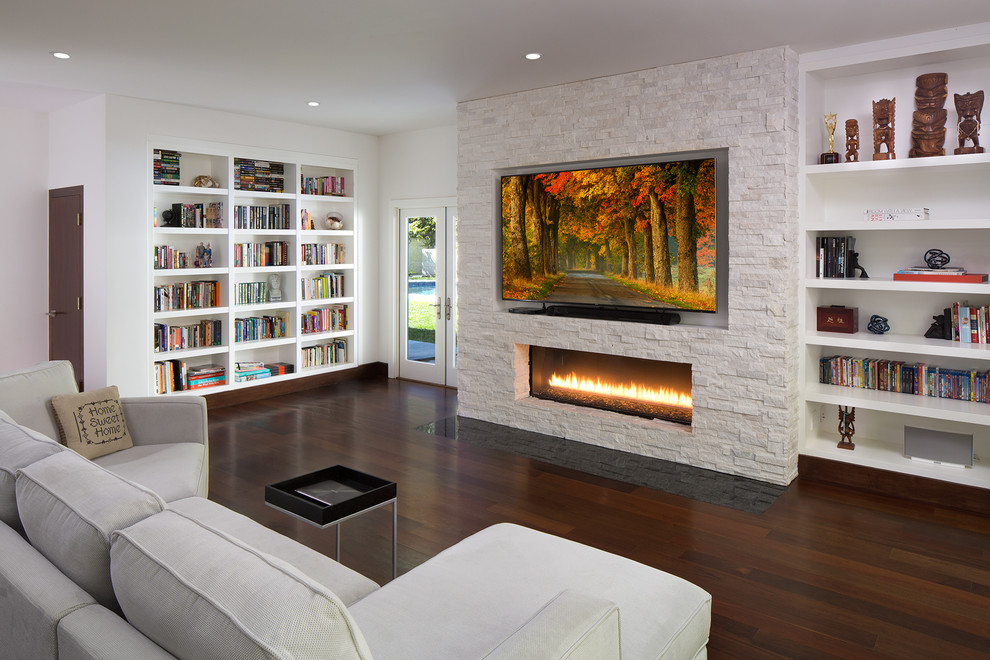 Photo of a medium sized contemporary open plan games room in Los Angeles with white walls, dark hardwood flooring, a ribbon fireplace, a stone fireplace surround, a reading nook, a built-in media unit and brown floors.