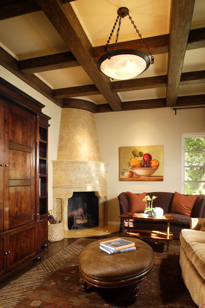 На фото: гостиная комната в средиземноморском стиле с угловым камином с