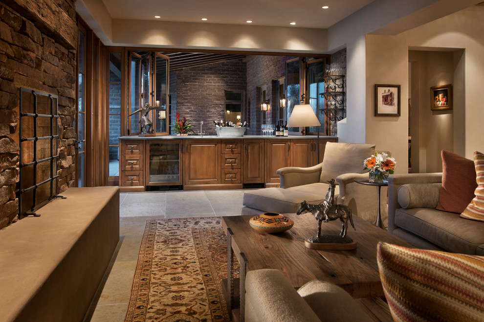 Inspiration for a large eclectic open plan games room in Phoenix with a home bar, beige walls, limestone flooring, a standard fireplace, a stone fireplace surround and a wall mounted tv.