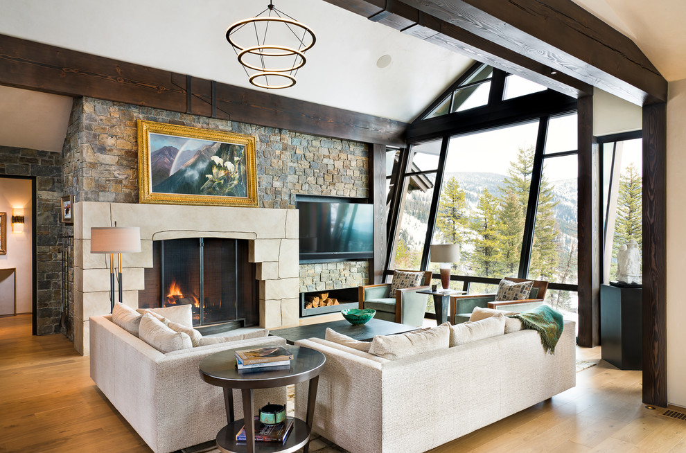 Diseño de sala de estar rural con suelo de madera clara, todas las chimeneas, televisor colgado en la pared y suelo beige