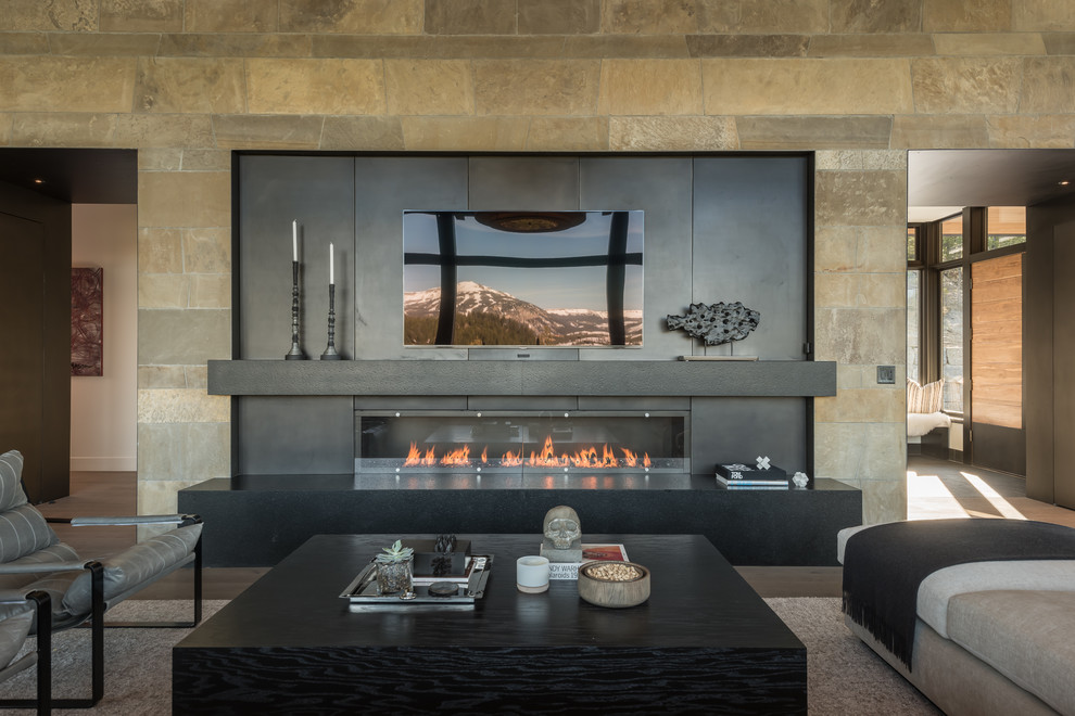 This is an example of a large contemporary open plan games room in Other with beige walls, medium hardwood flooring, a ribbon fireplace, a metal fireplace surround, a wall mounted tv and brown floors.