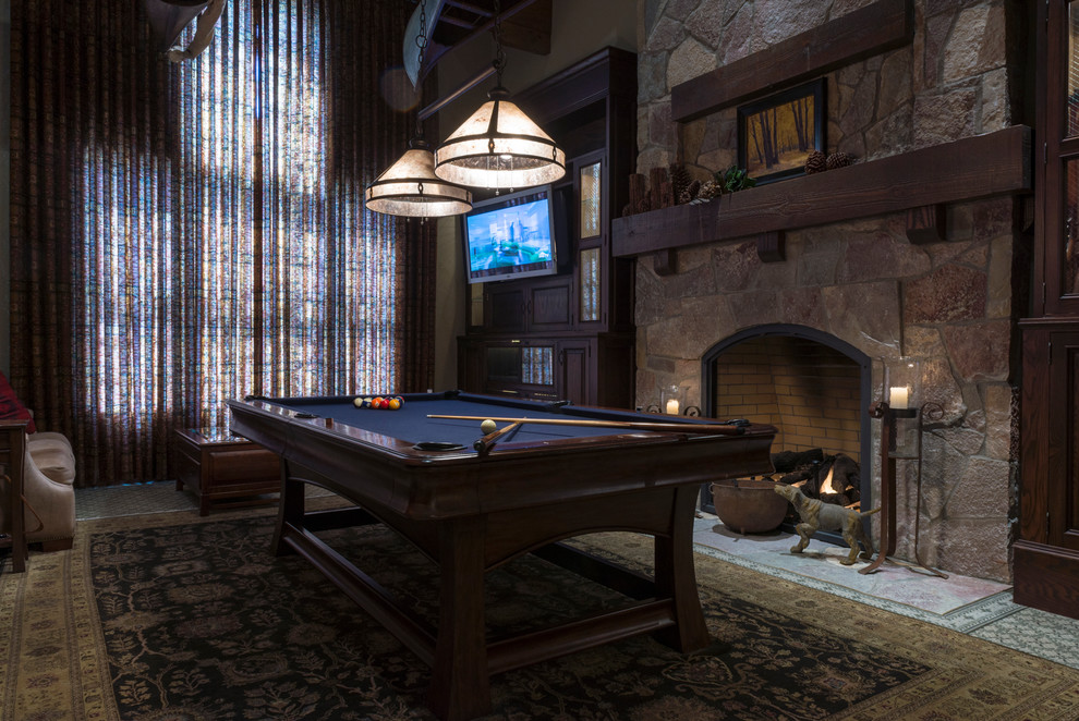 Large classic enclosed games room in Sacramento with a game room, beige walls, a standard fireplace, a stone fireplace surround, a wall mounted tv, carpet and multi-coloured floors.
