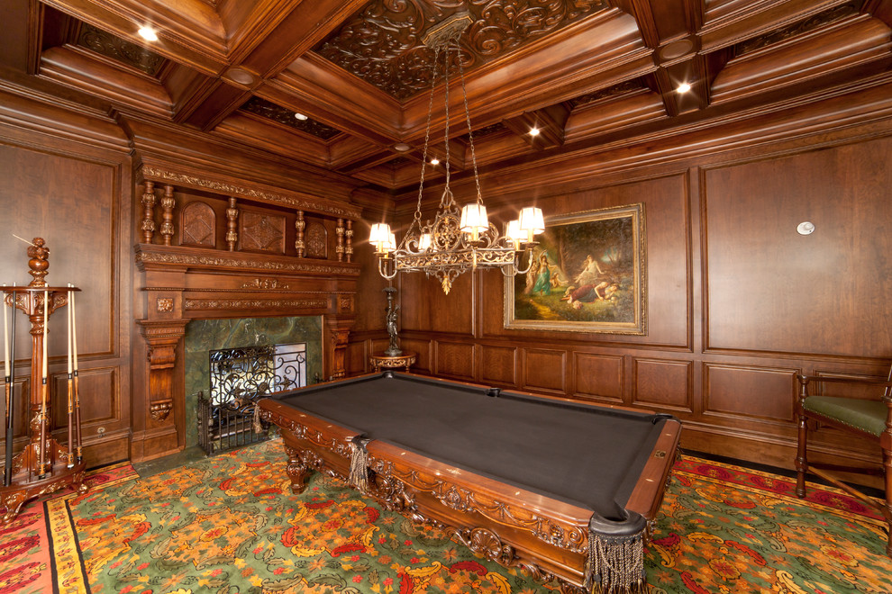 На фото: большая изолированная комната для игр в классическом стиле с коричневыми стенами, ковровым покрытием, стандартным камином, фасадом камина из камня и разноцветным полом без телевизора