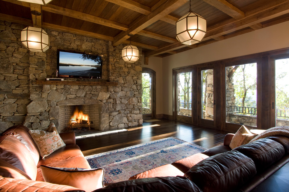 На фото: гостиная комната в классическом стиле с фасадом камина из камня и ковром на полу