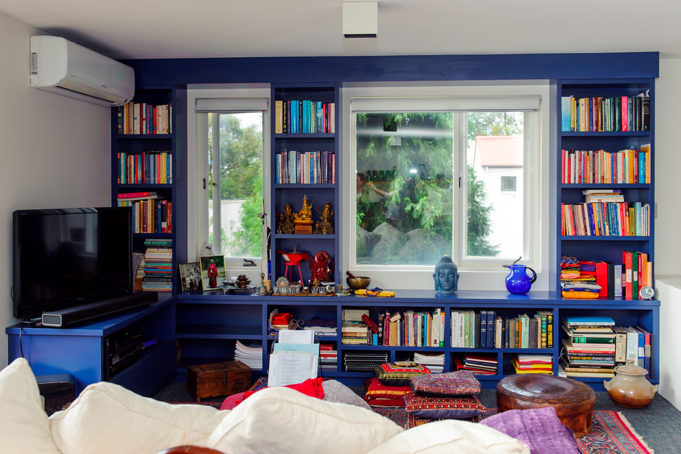 Ispirazione per un soggiorno eclettico di medie dimensioni e aperto con libreria, moquette, TV autoportante e pareti blu
