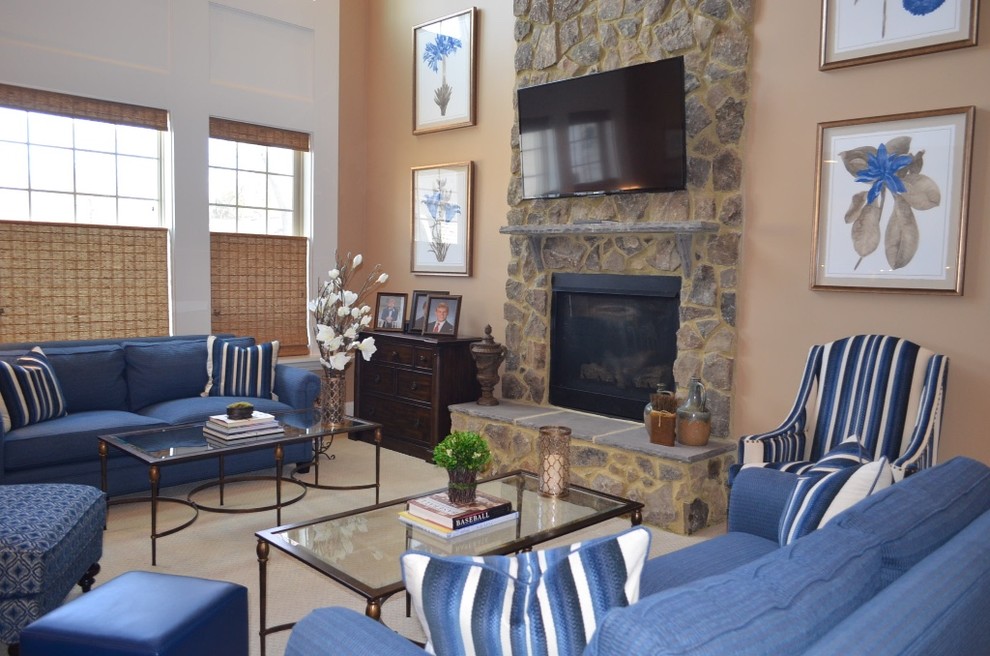 Foto de sala de estar abierta tradicional renovada grande con paredes beige, moqueta, todas las chimeneas, marco de chimenea de piedra, televisor colgado en la pared y suelo beige