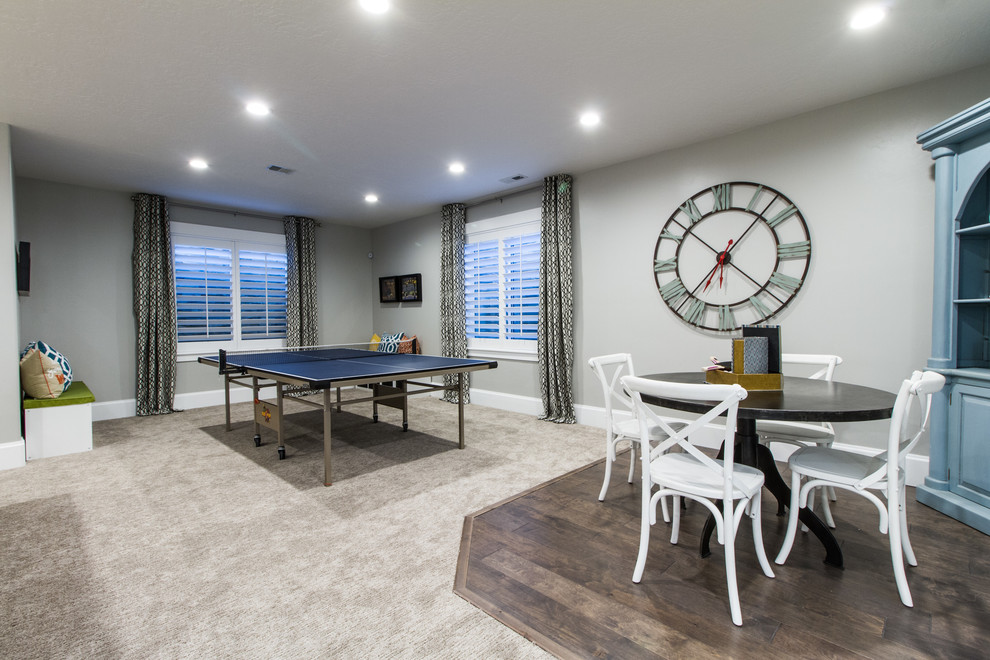 Imagen de sala de juegos en casa abierta de estilo americano de tamaño medio sin chimenea con paredes grises, moqueta, televisor colgado en la pared y suelo beige