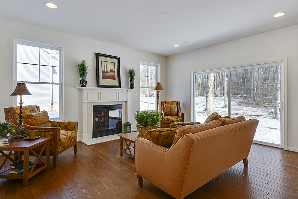 Cette image montre une salle de séjour rustique de taille moyenne et ouverte avec un mur blanc, un sol en bois brun, une cheminée standard, un manteau de cheminée en plâtre et aucun téléviseur.