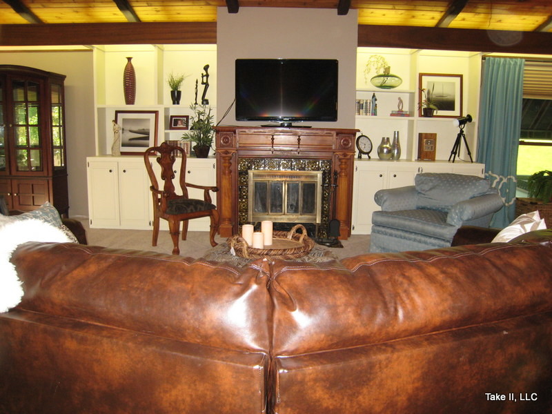 Großes, Offenes Klassisches Wohnzimmer mit beiger Wandfarbe, Teppichboden, Kamin, Kaminumrandung aus Holz und TV-Wand in Sonstige