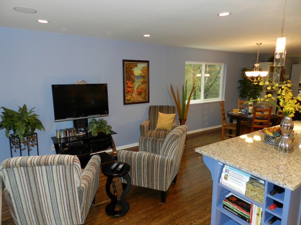 Idee per un soggiorno chic di medie dimensioni e aperto con pareti blu, pavimento in legno massello medio e TV autoportante