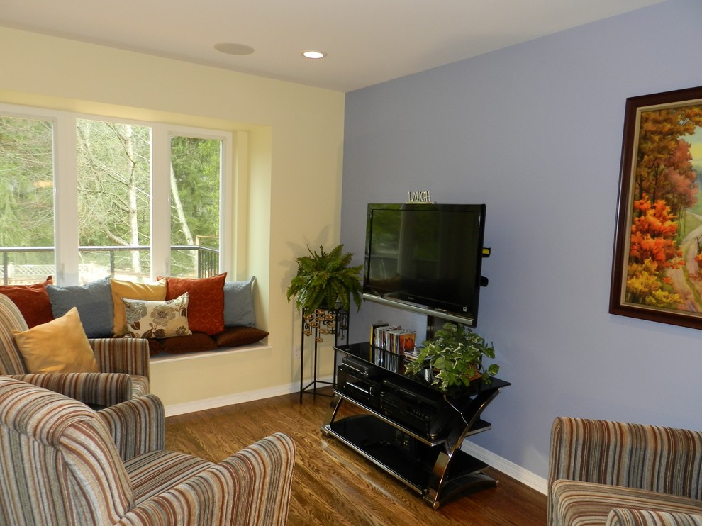 Imagen de sala de estar abierta clásica renovada de tamaño medio con paredes azules y suelo de madera en tonos medios
