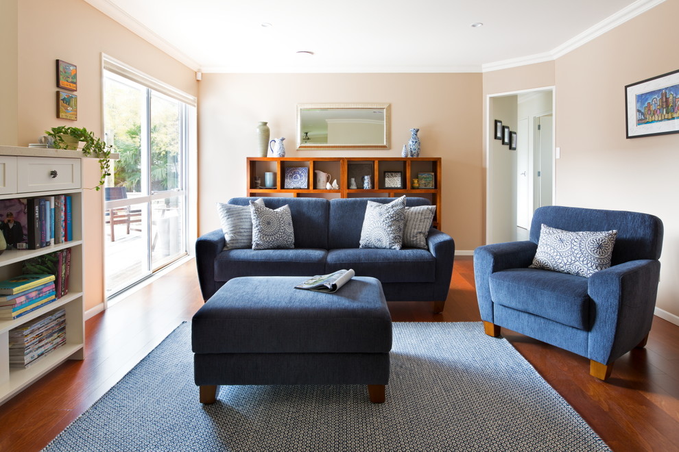 Immagine di un soggiorno chic di medie dimensioni e aperto con pareti beige, pavimento in legno massello medio, stufa a legna e TV a parete