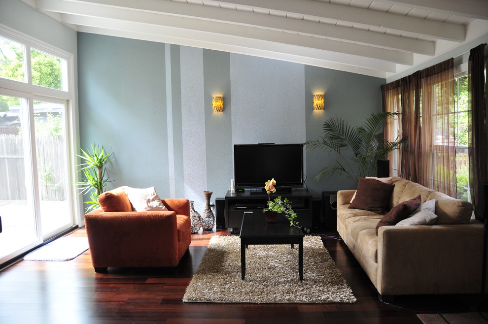 Свежая идея для дизайна: гостиная комната в современном стиле с синими стенами, темным паркетным полом и коричневым диваном - отличное фото интерьера