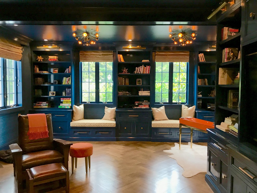 Idee per un grande studio classico con libreria, pareti blu, parquet scuro e pavimento marrone
