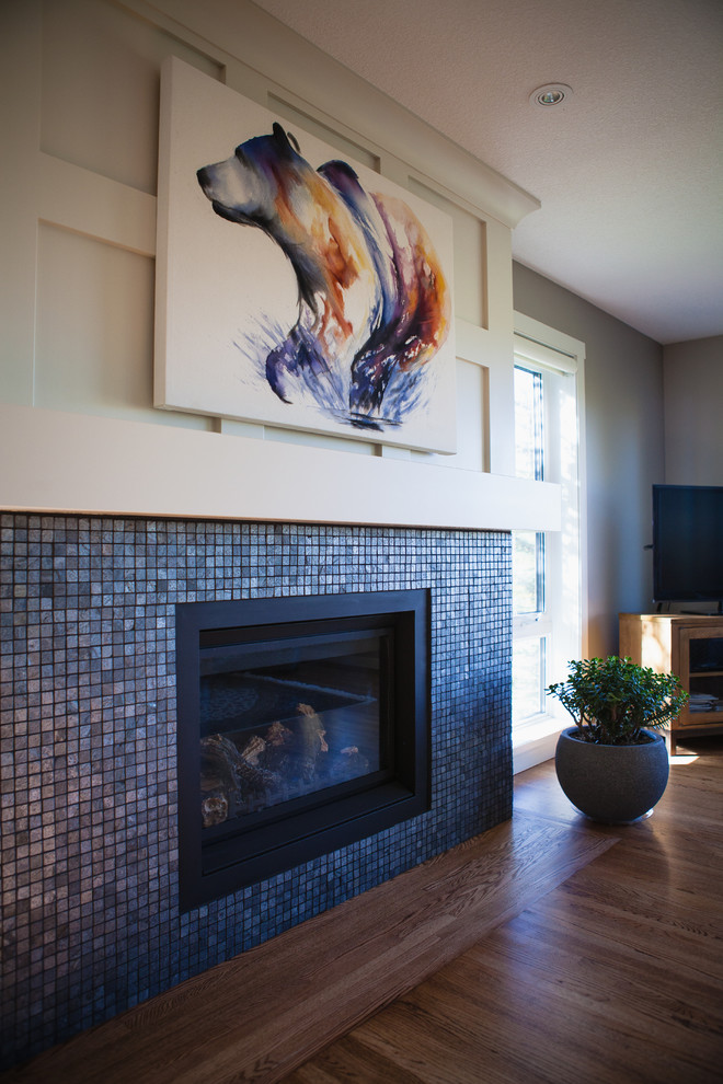 Ejemplo de sala de estar de estilo americano con suelo de madera clara, todas las chimeneas y marco de chimenea de baldosas y/o azulejos