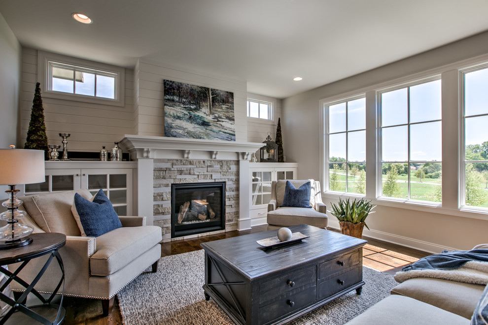 Design ideas for a large classic open plan games room in Omaha with medium hardwood flooring, a standard fireplace, a stone fireplace surround, grey walls, no tv and brown floors.