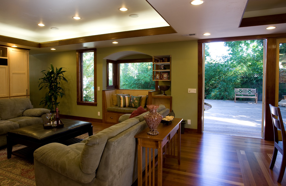 Idee per un grande soggiorno stile americano aperto con pareti verdi, pavimento in legno massello medio e parete attrezzata