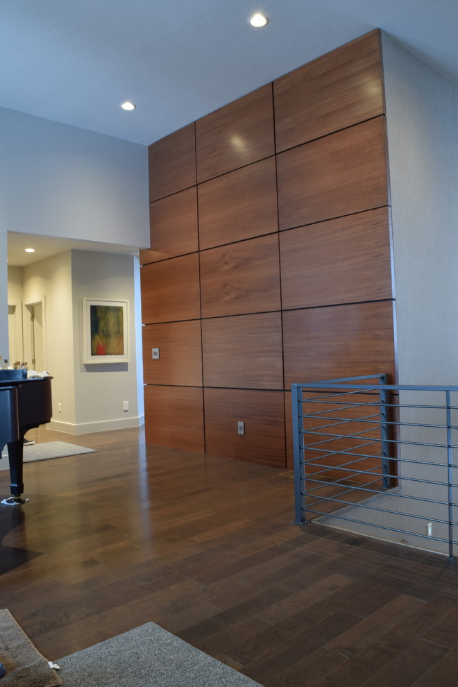 Пример оригинального дизайна: открытая гостиная комната среднего размера в современном стиле с музыкальной комнатой, белыми стенами, паркетным полом среднего тона, горизонтальным камином, фасадом камина из дерева, телевизором на стене и коричневым полом