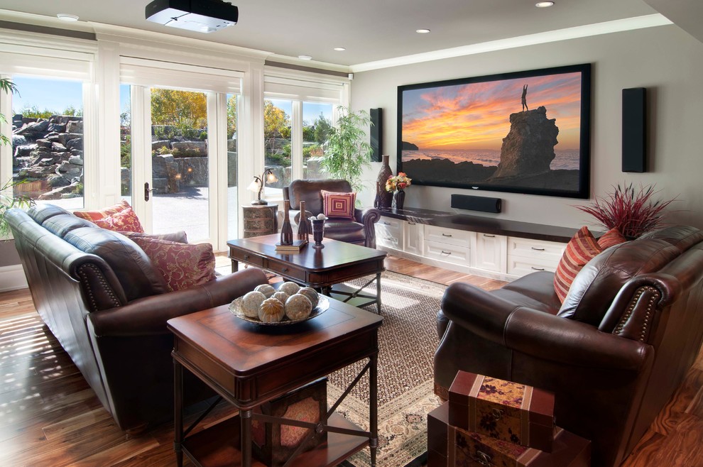 Mid-sized elegant medium tone wood floor family room photo in Calgary with gray walls and a wall-mounted tv