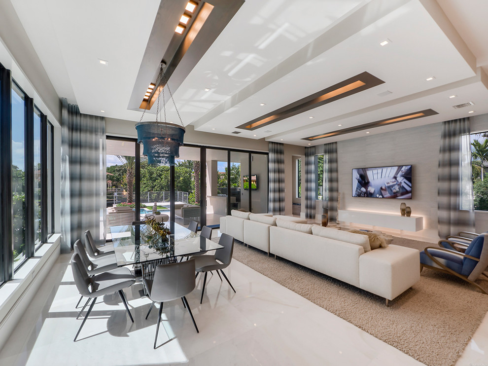 Inspiration for a mid-sized contemporary open concept marble floor family room remodel in Miami with gray walls, a wall-mounted tv and no fireplace