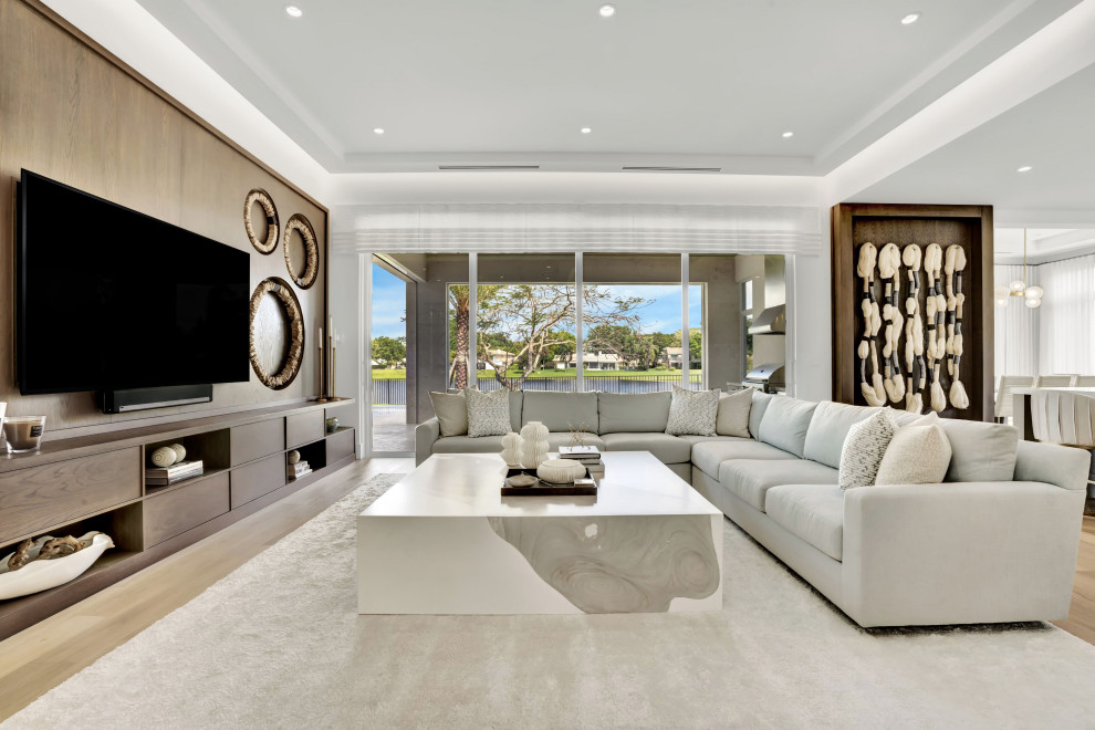 Aménagement d'une grande salle de séjour contemporaine ouverte avec un mur blanc, un sol en bois brun, un téléviseur encastré, un sol beige, un plafond à caissons et du papier peint.