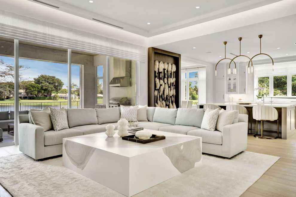 Modelo de sala de estar abierta contemporánea grande con paredes blancas, suelo de madera en tonos medios, pared multimedia, suelo beige, casetón y papel pintado