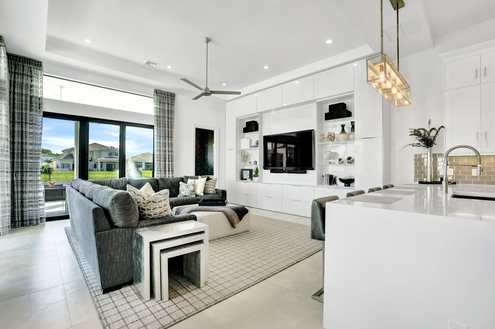 Diseño de sala de estar abierta actual grande con paredes blancas, suelo de baldosas de porcelana, televisor colgado en la pared y suelo gris