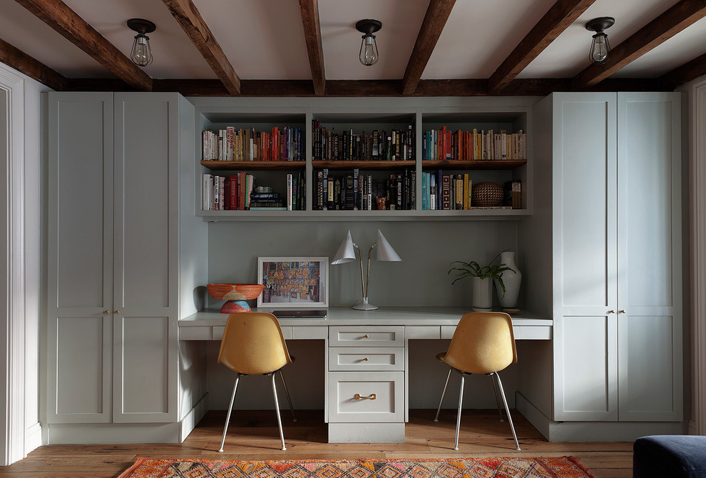 Imagen de sala de estar con biblioteca clásica renovada con suelo de madera en tonos medios