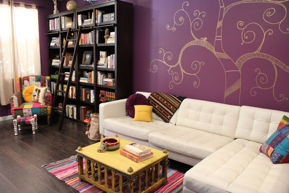 Ejemplo de sala de estar con biblioteca cerrada ecléctica grande con paredes púrpuras, suelo de madera oscura, televisor independiente y suelo marrón