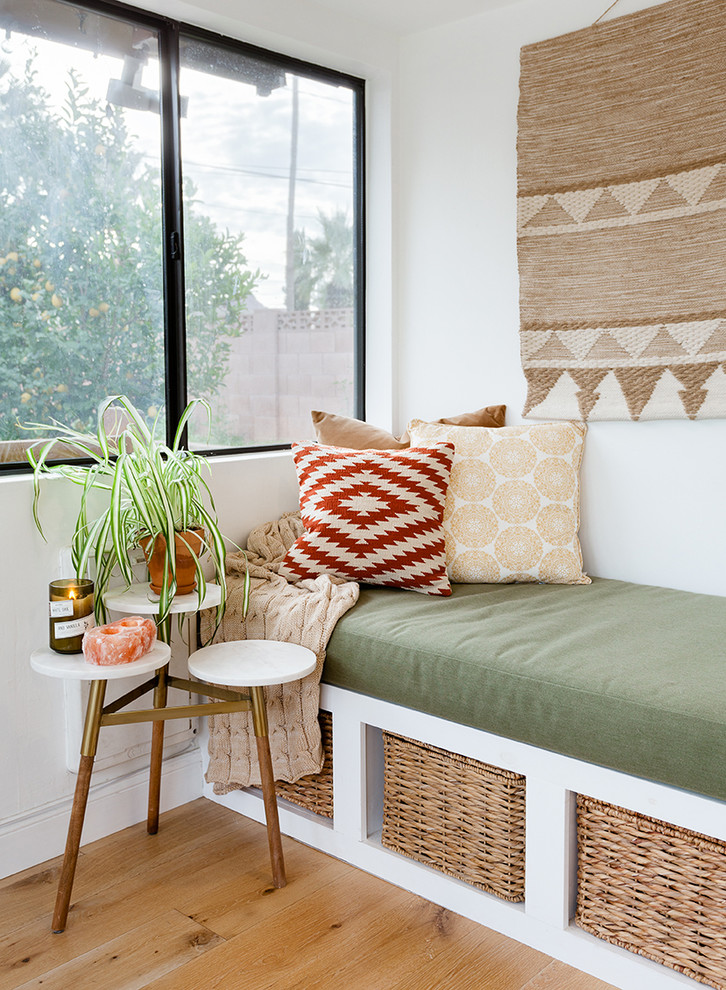 Imagen de sala de estar abierta bohemia pequeña con paredes blancas y suelo de madera clara