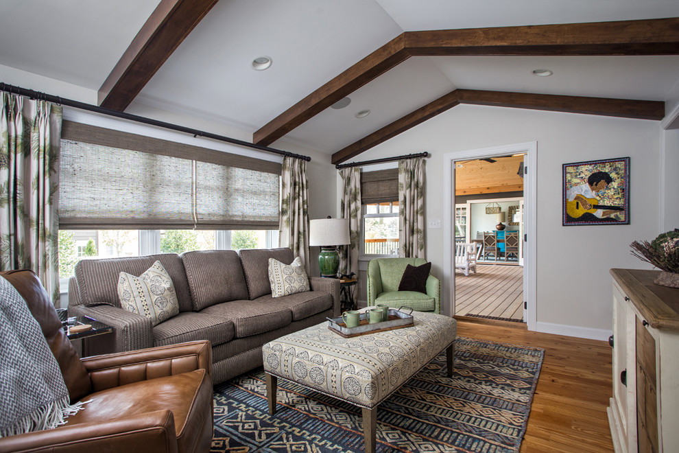 Ejemplo de sala de estar tipo loft bohemia grande sin chimenea y televisor con paredes blancas, suelo de madera en tonos medios y suelo marrón