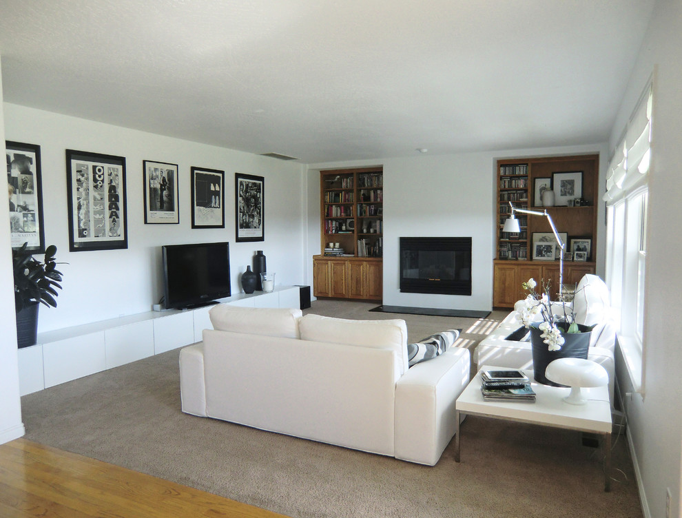 На фото: большая открытая гостиная комната в стиле модернизм с белыми стенами, ковровым покрытием, стандартным камином, фасадом камина из металла и отдельно стоящим телевизором с