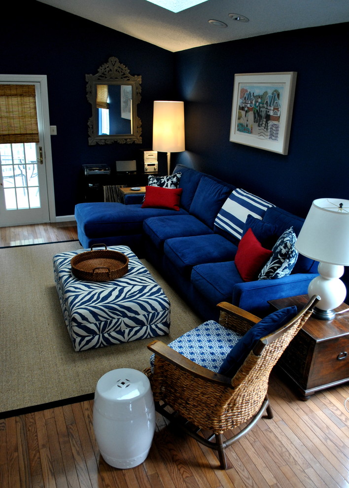 Example of a large eclectic loft-style medium tone wood floor family room library design in Philadelphia with blue walls, a concealed tv and no fireplace