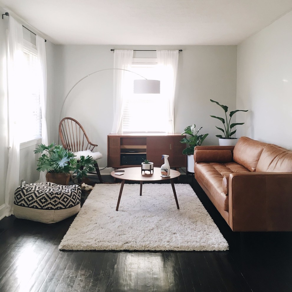 Family room - mid-century modern dark wood floor family room idea in Other with white walls