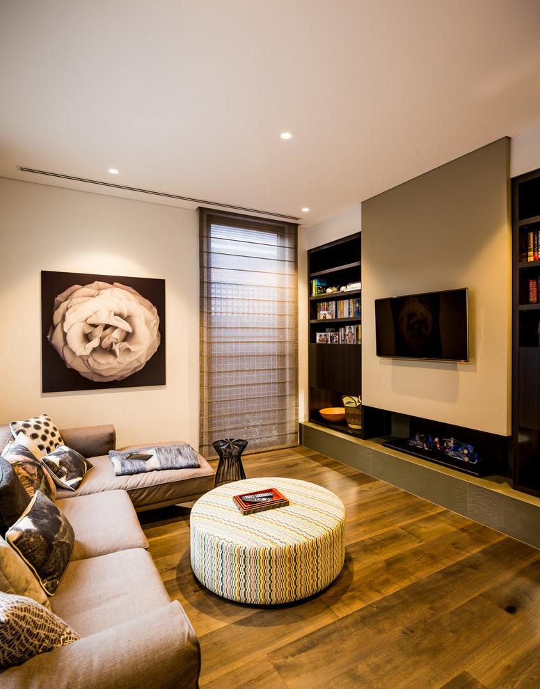 Immagine di un soggiorno minimal di medie dimensioni con pareti bianche, TV a parete e pavimento in legno massello medio
