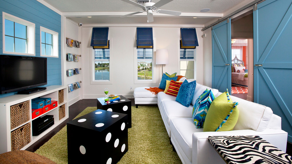 Immagine di un soggiorno stile marinaro chiuso con parquet scuro, TV autoportante, pareti multicolore e pannellatura